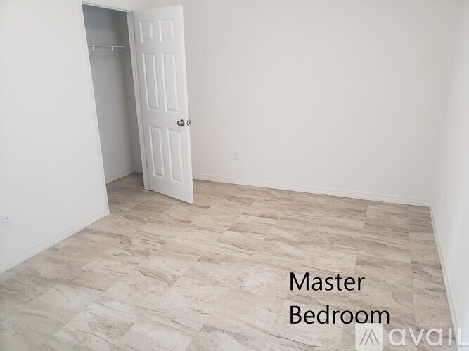 A master bedroom with a door and a tiled floor.