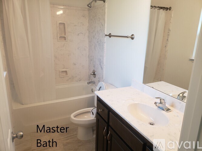 A bathroom with a toilet, sink, and shower.