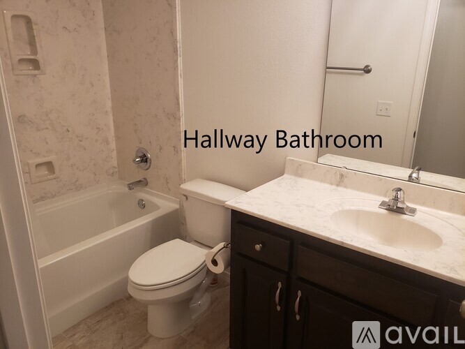 A bathroom with a toilet, sink, and bathtub.