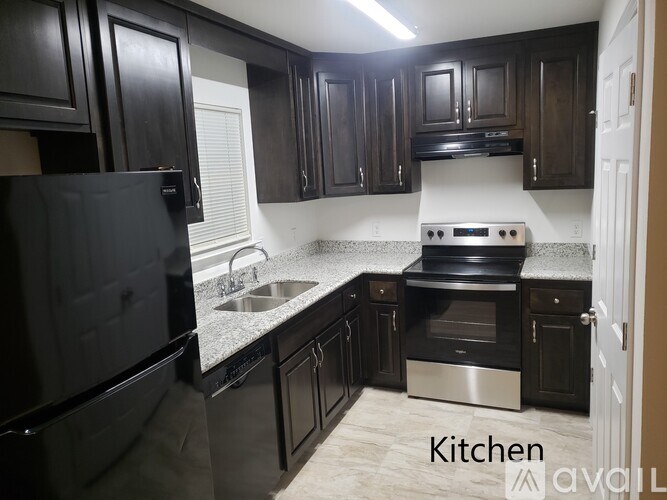 A kitchen with black cabinets and stainless steel appliances.