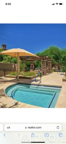 A pool with a sun umbrella and a slide in the background.