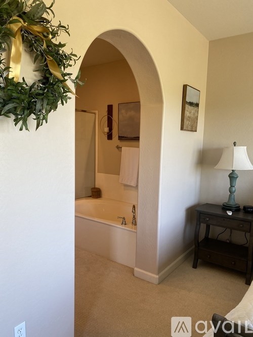 A bathroom with a tub and a wreath on the wall.
