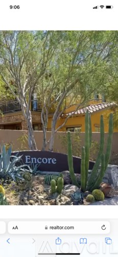 A cactus garden in front of a building with a sign that reads "Encore".
