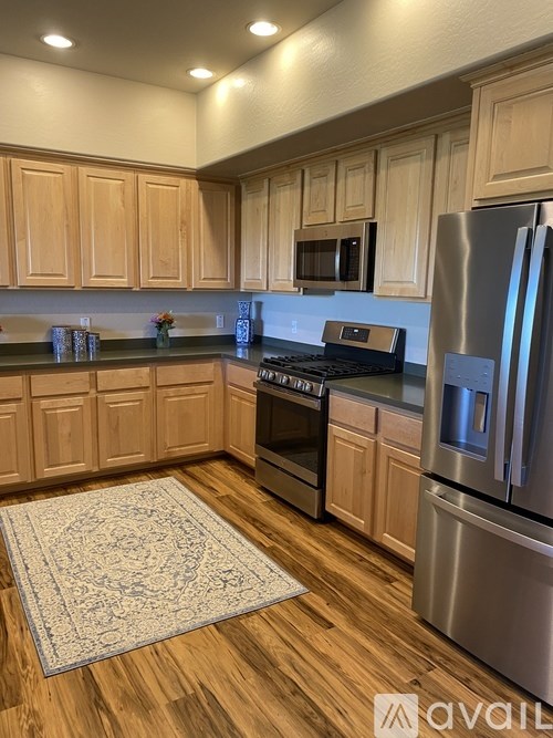 A kitchen with wooden cabinets and a rug on the floor.