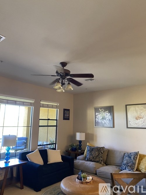 A living room with a couch, a coffee table, and a ceiling fan.