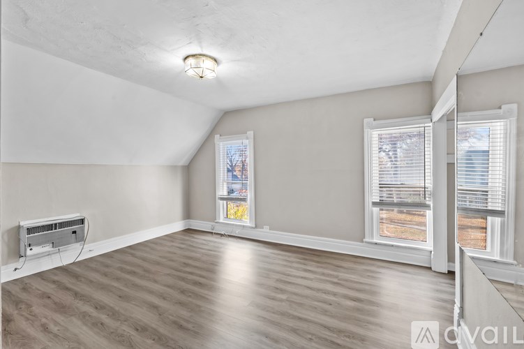 A room with a window and a wall-mounted air conditioner unit.