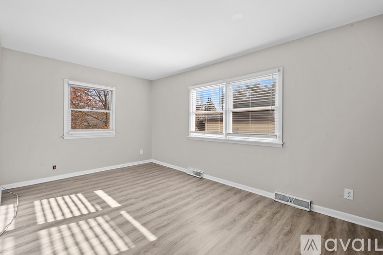 A room with a window and a picture on the wall.