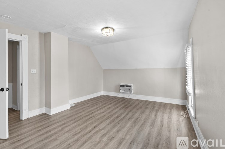 A room with wooden flooring and a white ceiling with a light fixture.