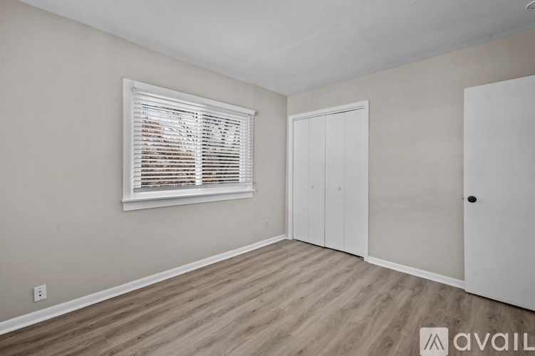 A room with a window and a door is available for rent.