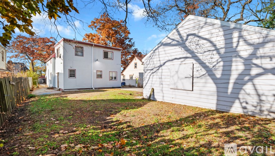 A white house with a shadow of a tree on its side.
