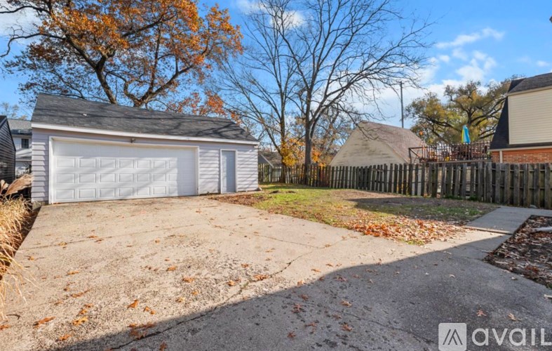 A detached house with a white garage door is for sale.