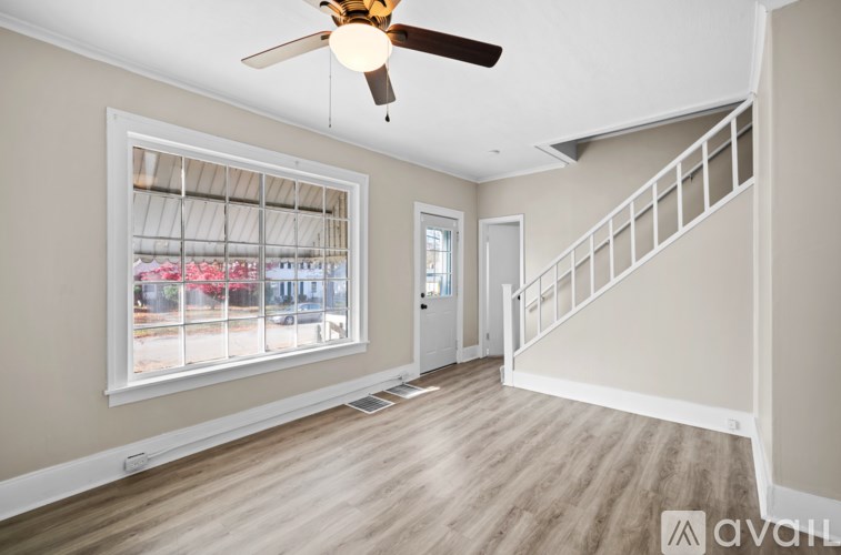 A room with a ceiling fan and a staircase.