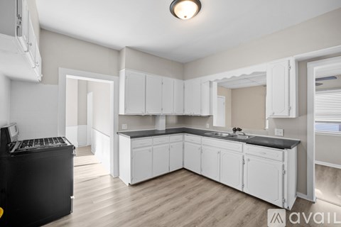 A kitchen with white cabinets and a black dishwasher.