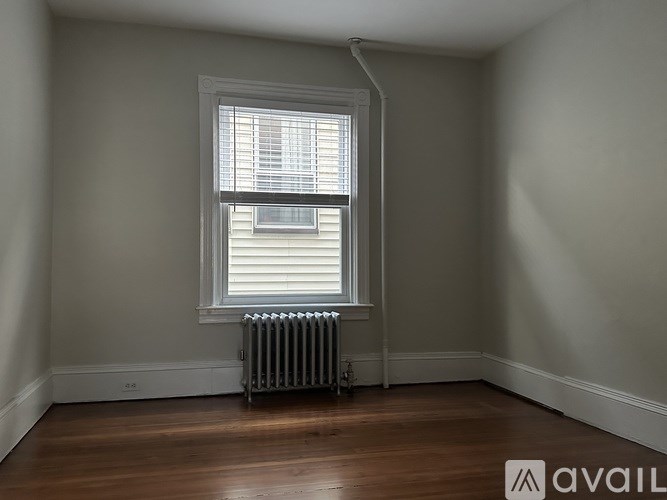 A room with a window and a radiator on the floor.