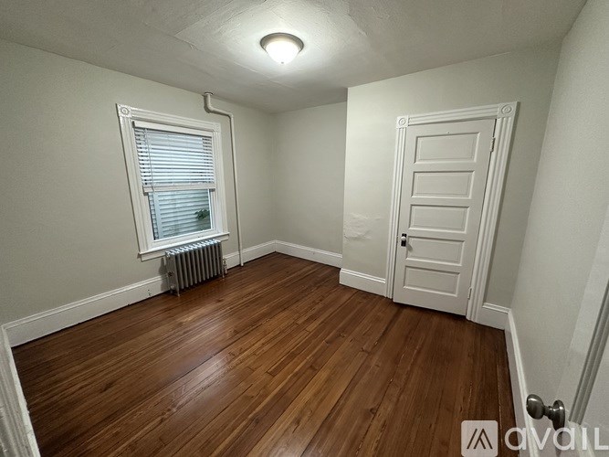 A room with a wooden floor and a white door.