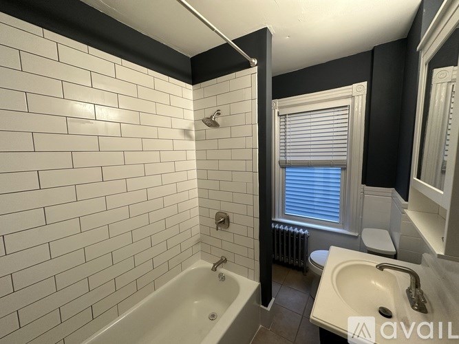 A bathroom with a white tiled shower area.