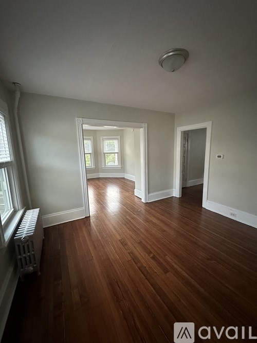 A room with wooden floors and a window with blinds.