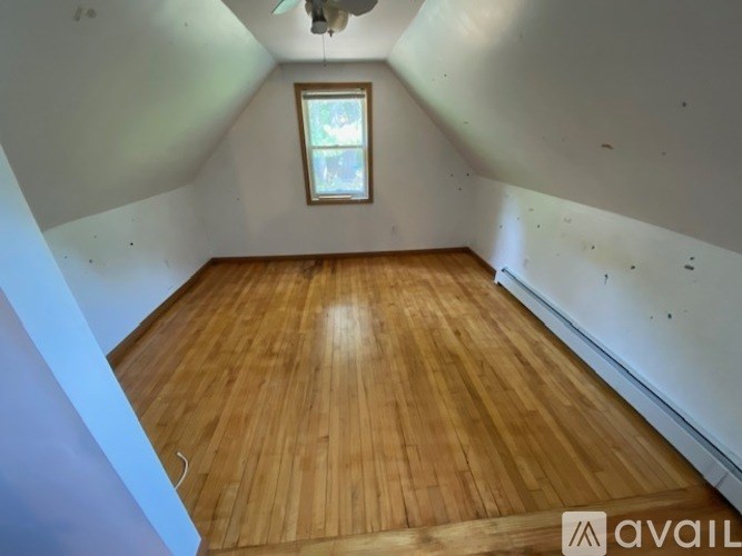 A room with wooden flooring and a window.