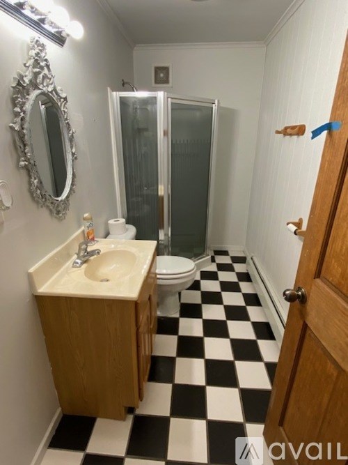 A bathroom with a sink, mirror, toilet and shower.
