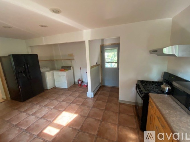 A kitchen with brown tiles on the floor.