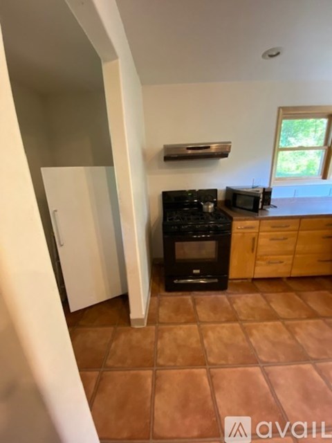 A kitchen with brown tiles on the floor.