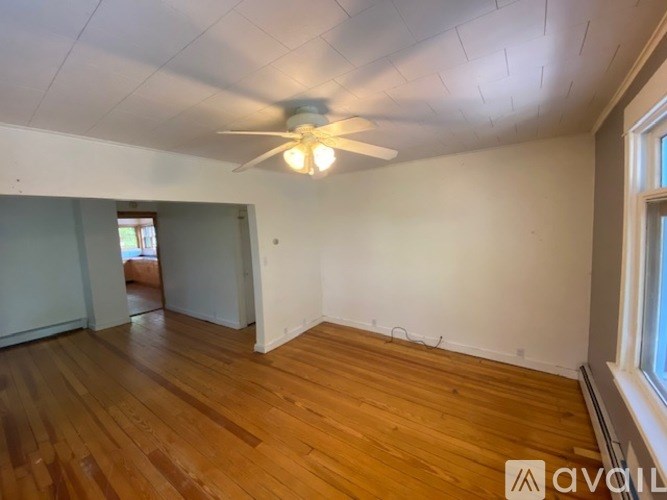 A room with wooden floors and a ceiling fan.