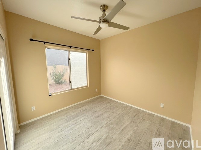 A room with a ceiling fan and sliding glass doors.