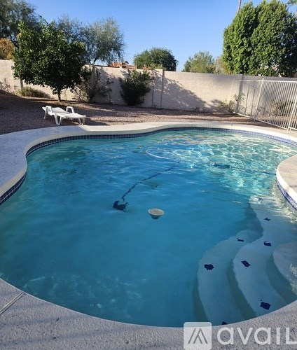 A pool with a white chair and a diving board.