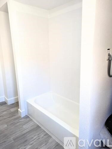 A bathroom with a tub and a shower head.
