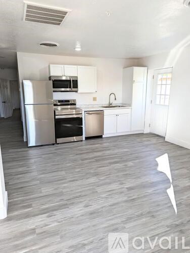 A kitchen with a refrigerator, stove, and sink.