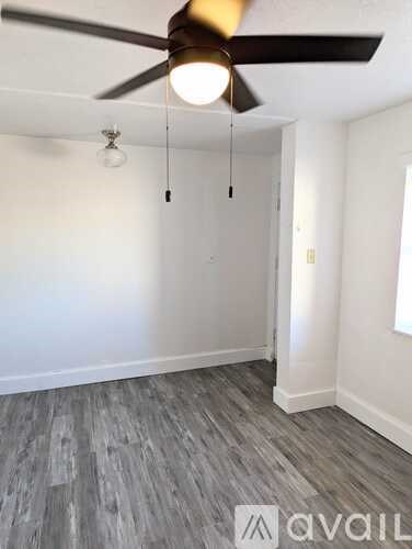 A room with a ceiling fan and a light hanging from the ceiling.