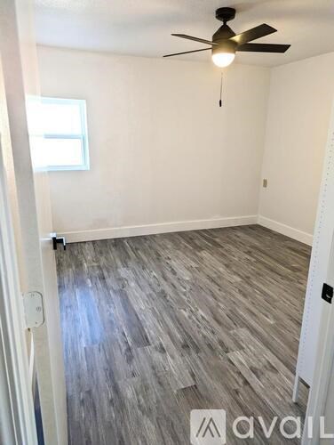 A room with a ceiling fan and a window.