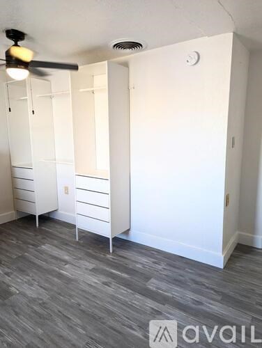 A room with a fan and a cabinet.