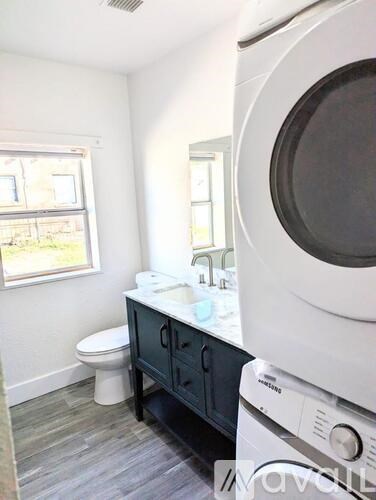 A small bathroom with a toilet, sink, and a washing machine.