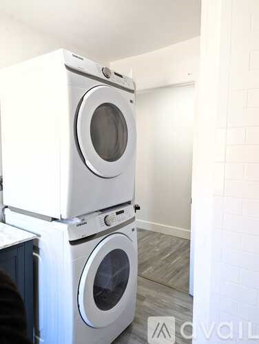 Two stacked washing machines in a laundry room.