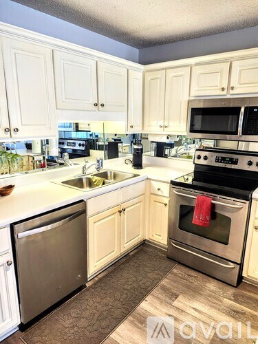 A kitchen with white cabinets and a black stove top oven.