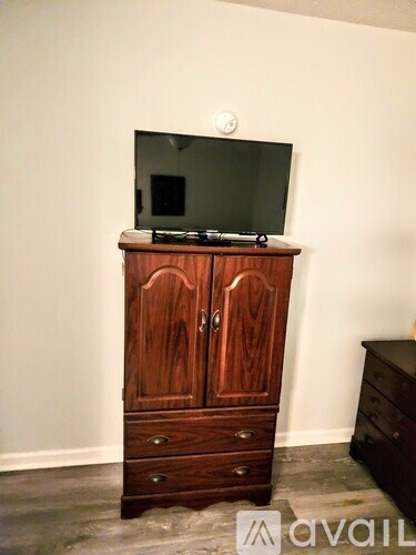 A wooden cabinet with a flat screen TV on top of it.