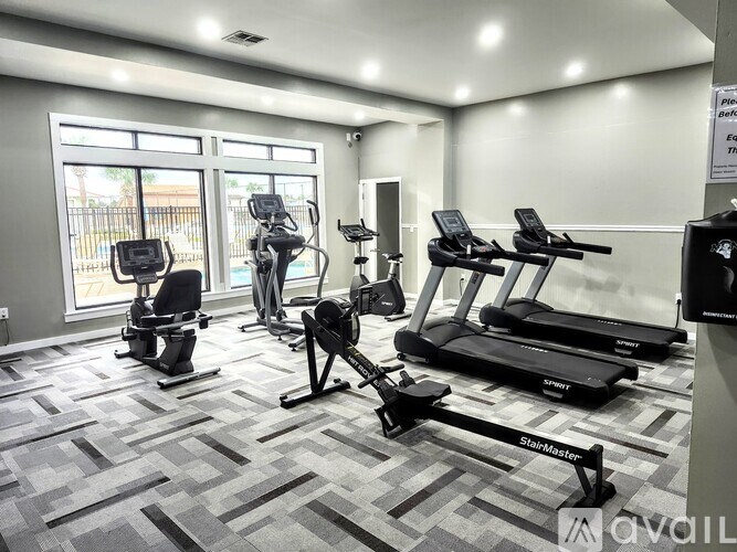A gym with treadmills, elliptical machines, and other exercise equipment.