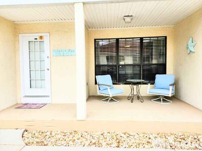 A patio with a table and chairs and a door.