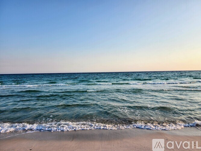 A beach with waves coming in from the ocean.