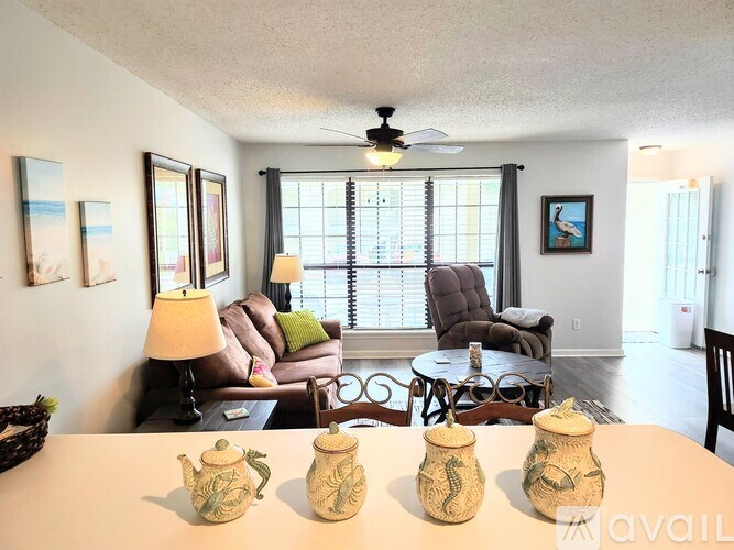 A living room with a couch, chair, and table.
