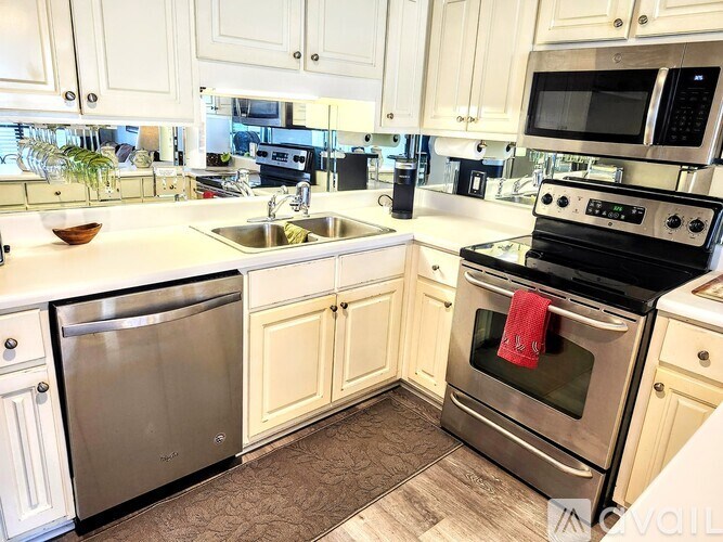 A kitchen with white cabinets and a stainless steel dishwasher.