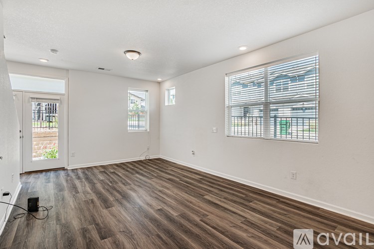 A room with wooden flooring and a window with blinds.