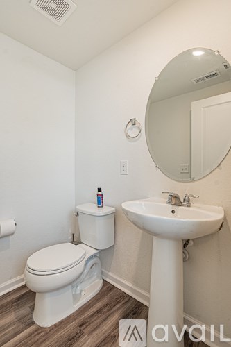 A white toilet and sink in a bathroom.