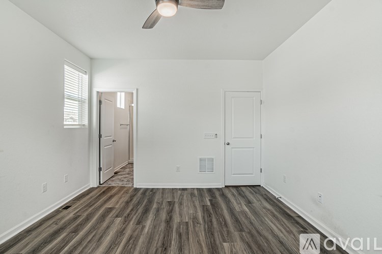A room with a wooden floor and a ceiling fan.