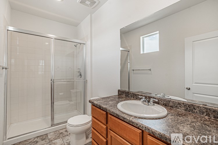 A bathroom with a marble countertop and a walk-in shower.