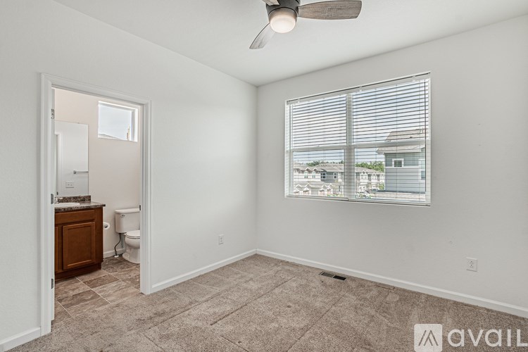 A room with a ceiling fan and a window with blinds.