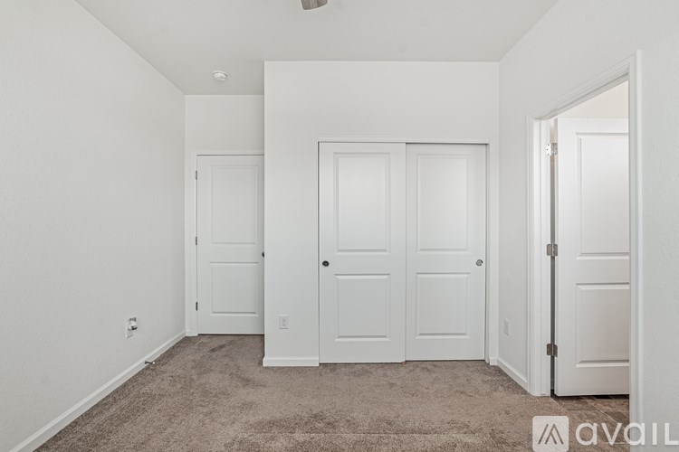 A room with three white doors and a carpeted floor.