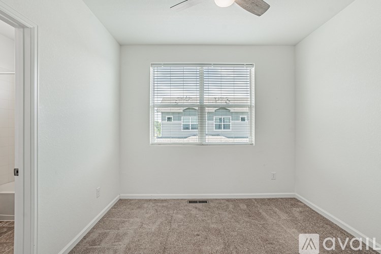 A room with a window and a fan on the ceiling.