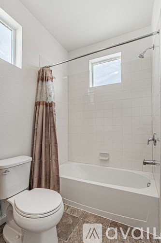 A bathroom with a toilet, a bathtub, and a shower.